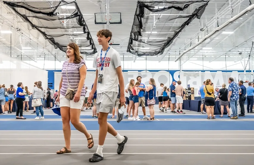 Two visitors walk inside the Wellness and 娱乐 center during an activity fair.